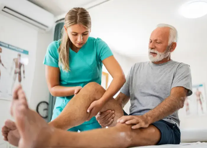 physiotherapist providing manual therapy to an old man